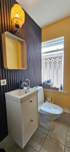 a bathroom with a toilet and a sink and a window at Árból Guesthouse in Húsavík +63 photos