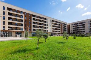 a large building with a green field in front of it at Numa by Kraft in Podgorica
