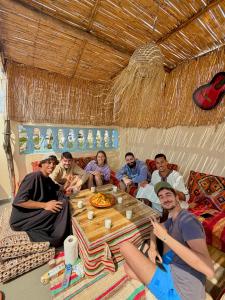 a group of people sitting around a table in a room at Waveside surf house in Tamraght Ou Fella +32 photos
