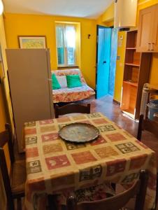 a kitchen with a table and a room with a bed at Appartamento Margherita in Montale