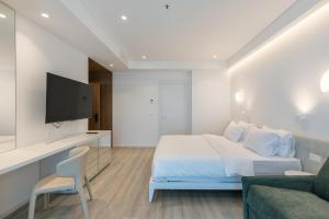 a bedroom with a bed and a tv and a couch at Nava Star Hotel in Durrës