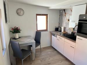 a small kitchen with a table and a clock on the wall at Fewo Kleine Gasse, super Zentral, Privat Parkplatz, in Ruhla