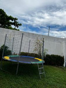 a trampoline in the grass next to a wall at Pousada Brisa do Oceano - Cumbuco in Cumbuco