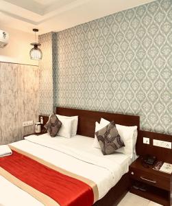 a bedroom with a large bed with a red blanket at Hotel Asha in Kannauj