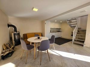 a room with a table and chairs and a kitchen at Cosy Hideaway Guest House in Dovilai