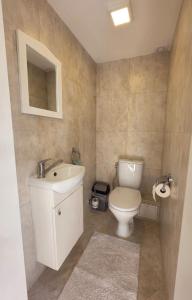 a bathroom with a white sink and a toilet at Cosy Hideaway Guest House in Dovilai +33 photos