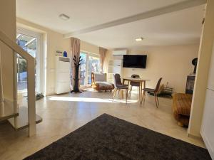 a large living room with a table and chairs at Cosy Hideaway Guest House in Dovilai