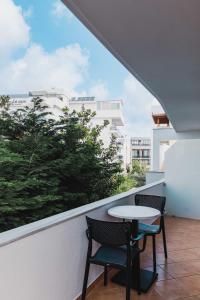 a balcony with two chairs and a table and a window at Villa White in Ksamil
