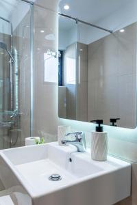 a white bathroom with a sink and a shower at Villa White in Ksamil +82 photos