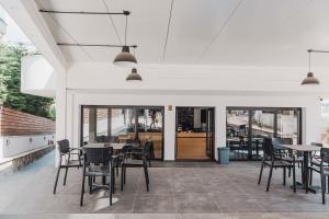 a dining room with tables and chairs and windows at Villa White in Ksamil