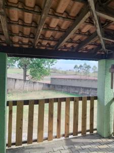 a wooden fence with a view of a field at Chácara do Neno in Limeira