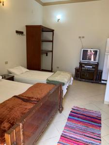 a bedroom with two beds and a flat screen tv at Kabeel's House in Dahab