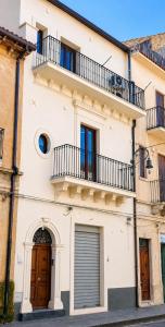 a white building with two balconies on top of it at Sosta al 101 - Alloggio turistico in Grammichele