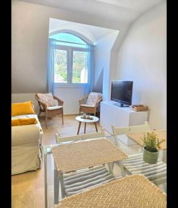 a living room with a couch and tables and a tv at Ático Formoso in Cee