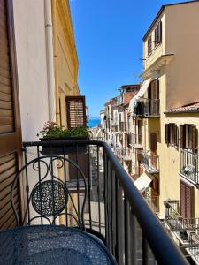 a balcony with a table and a view of a city at Civico5 - Spazioso appartamento 110 mq a Cefalù in Cefalù