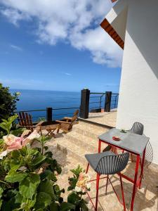 a patio with a table and chairs and the ocean at TheView in Funchal