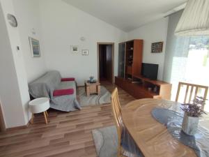 a living room with a table and a dining room at Apartman Goga i Dragan in Drage