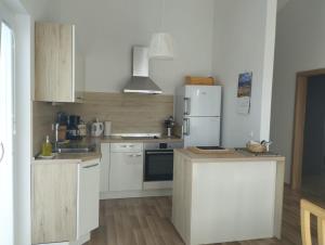 a kitchen with white cabinets and a white refrigerator at Apartman Goga i Dragan in Drage