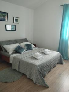 a bedroom with a large bed with blue curtains at Apartman Goga i Dragan in Drage