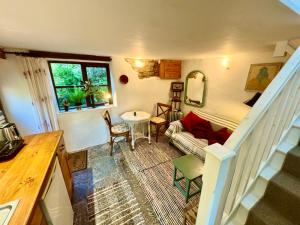 a living room with a couch and a table at Garden Cottage Wiveliscombe in Wiveliscombe