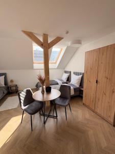 a living room with a table and chairs and a bed at Willa Nowa 33 in Wisła