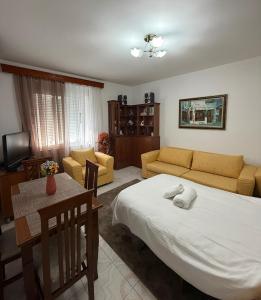 a bedroom with a bed and a couch and a table at Alex Guest Apartment in Gjirokastër