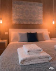 a group of towels sitting on top of a bed at La Maison Fois - Appartamento Quartucciu in Quartucciu +10 photos