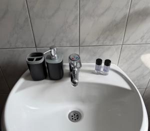 a bathroom sink with two cups and a faucet at Alex Guest Apartment in Gjirokastër +32 photos
