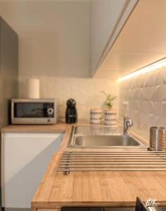 a kitchen with a sink and a microwave on a counter at La Maison Fois - Appartamento Quartucciu in Quartucciu