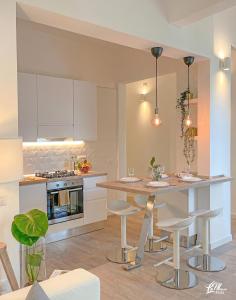 a kitchen with a table and stools in a room at La Maison Fois - Appartamento Quartucciu in Quartucciu