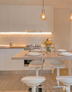 a kitchen with a table with chairs and glasses at La Maison Fois - Appartamento Quartucciu in Quartucciu