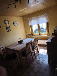 a dining room with a table and chairs and a window at Ferienhaus König in Kurort Steinbach-Hallenberg