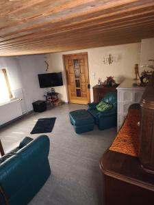 a living room with blue couches and a tv at Ferienhaus König in Kurort Steinbach-Hallenberg