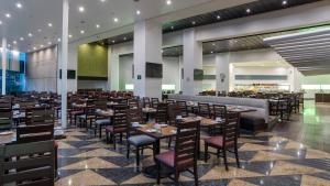 a restaurant with tables and chairs in a room at Holiday Inn Mexico City-Plaza Universidad by IHG in Mexico City