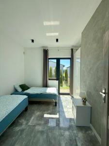 a bedroom with two beds and a window at Domki, Apartamenty U Adama i Ewy Morska Bryza Gąski, jacuzzi, sauna in Gąski