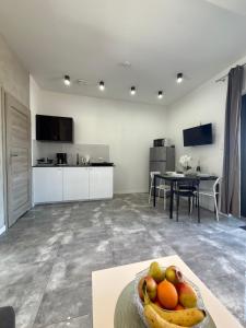 a kitchen and living room with a bowl of fruit on a table at Domki, Apartamenty U Adama i Ewy Morska Bryza Gąski, jacuzzi, sauna in Gąski