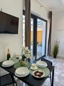 a black table with plates and food on it at Domki, Apartamenty U Adama i Ewy Morska Bryza Gąski, jacuzzi, sauna in Gąski +25 photos