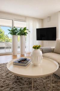 a living room with a table and two vases with plants at Bodensee Loft in Daisendorf