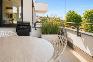 a table and chairs on a balcony with a stove at Bodensee Loft in Daisendorf