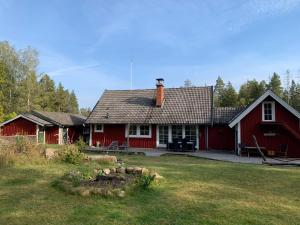 a red house with a yard in front of it at Villa Yasjö in Eringsboda