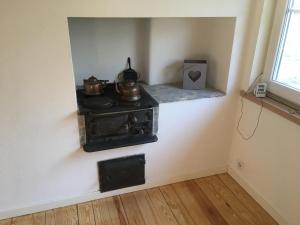 a stove with pots and pans on a wall in a room at Villa Yasjö in Eringsboda