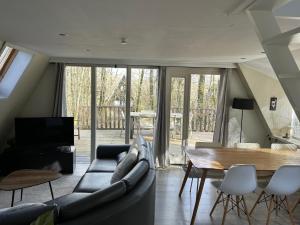 a living room with a couch and a table at Woodpecker - bungalow 29 in Durbuy