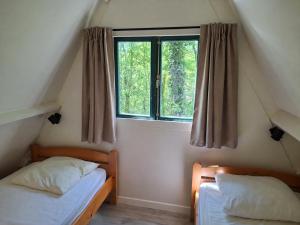 two twin beds in a room with a window at Woodpecker - bungalow 29 in Durbuy +28 photos