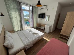a bedroom with a bed and a large window at Laguna Boutique Hotel Bazaleti Lake in Dushetʼi