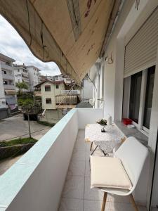a balcony with a table and chairs on a building at Alex Guest Apartment in Gjirokastër