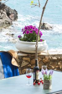 a table with a bottle of wine and two glasses at Gorgones, sea-front, great view in Kardamyli