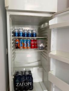 an open refrigerator filled with drinks and sodas at Alex Guest Apartment in Gjirokastër