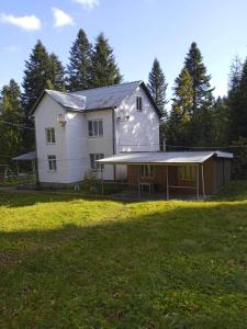 a large white house with a garage in a field at Ksenia pansionat in Skhidnitsa