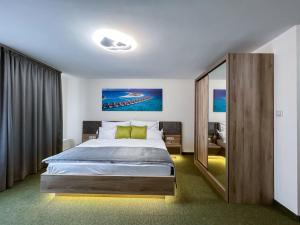a bedroom with a large bed and a large mirror at Rengő Panzió in Taksony