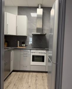 a kitchen with white cabinets and a stainless steel refrigerator at Hansa Living 3 Hamburg - Ruhiges Zimmer mit Gemeinschaftsküche in Hamburg